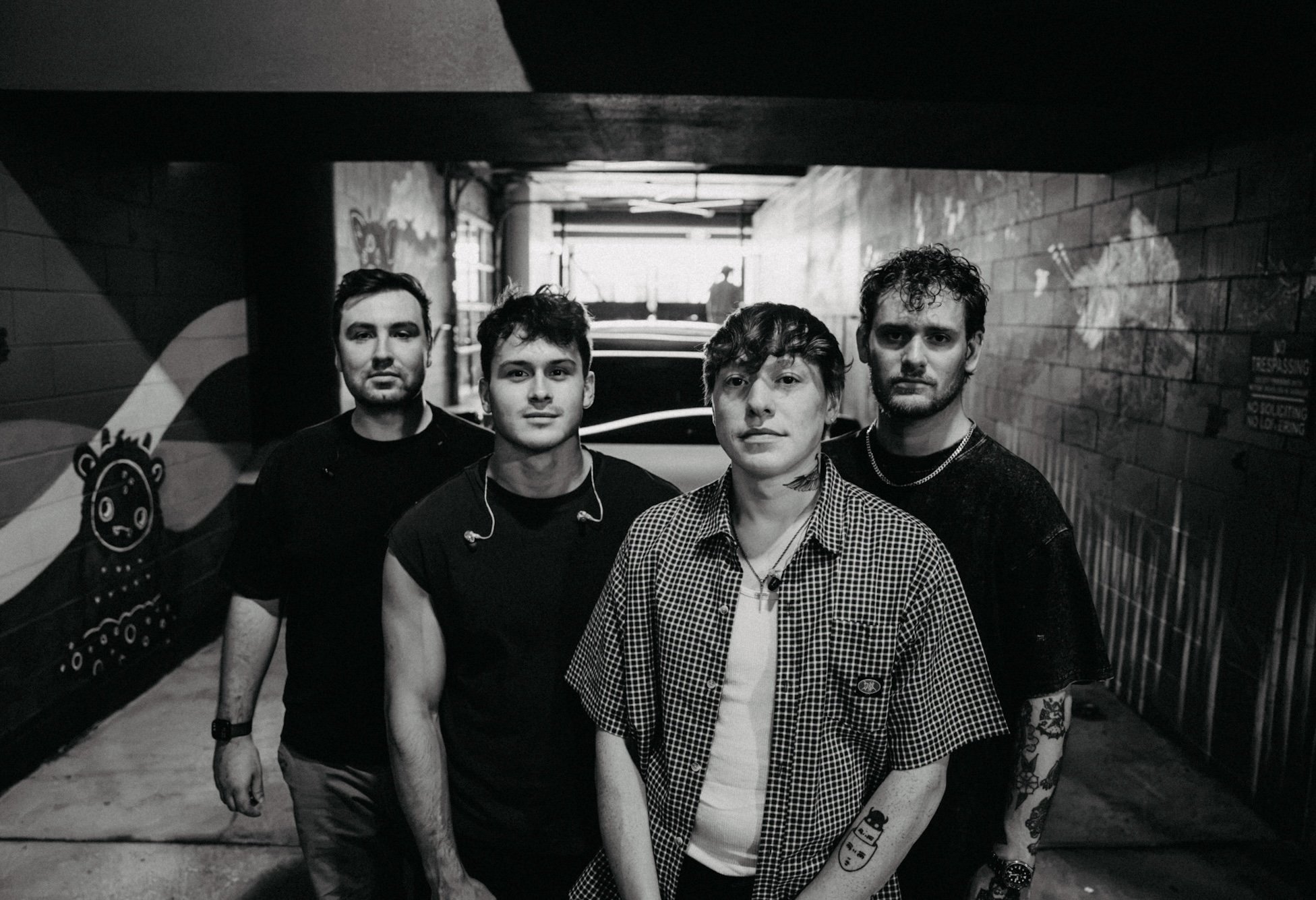 roo standing with the band in a black-and-white portrait